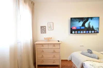 a bedroom with a dresser and a tv on the wall at Vistas al Mar in Puerto de Sagunto