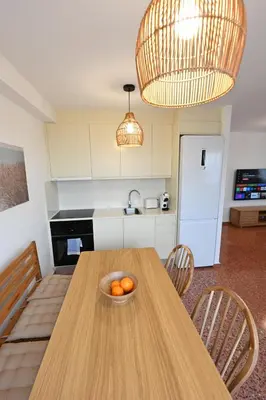 a kitchen with a wooden table with a bowl of oranges on it at Vistas al Mar in Puerto de Sagunto