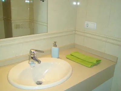 a bathroom sink with a green towel and a soap at Mestalla Silence in Valencia