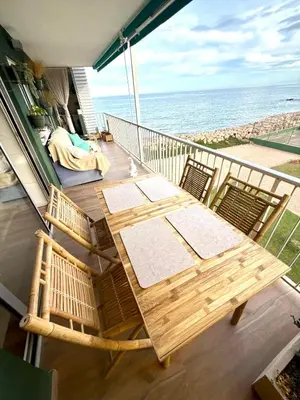 a balcony with a table and chairs and the ocean at Apartamento tranquilo y luminoso junto al mar in Cullera