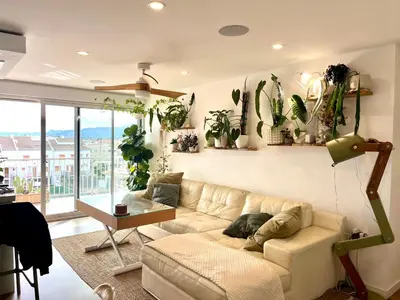 a living room with a couch and lots of plants at Apartamento tranquilo y luminoso junto al mar in Cullera