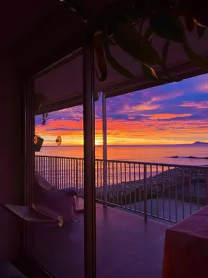 a room with a view of the beach at sunset at Apartamento tranquilo y luminoso junto al mar in Cullera