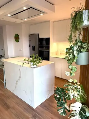 a kitchen with a white counter and some plants at Apartamento tranquilo y luminoso junto al mar in Cullera