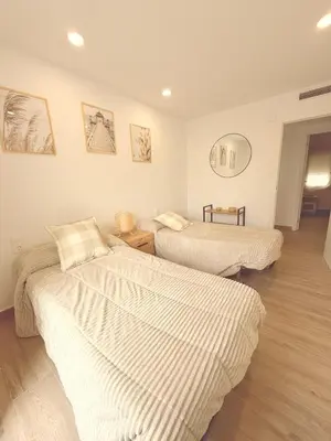a bedroom with two beds with white sheets at Puerto Beach House in Puebla de Farnals