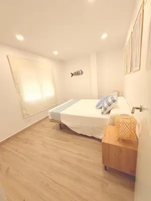 a bedroom with a large bed and a window at Puerto Beach House in Puebla de Farnals