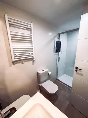 a bathroom with a toilet and a window and a sink at Primera línea en playa de Cullera in Cullera