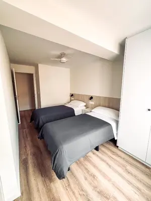 two beds in a room with wooden floors at Primera línea en playa de Cullera in Cullera