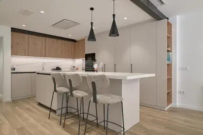 a kitchen with white counters and bar stools at Luxury Romantic Apartment Mestalla by Virkin Suites in Valencia