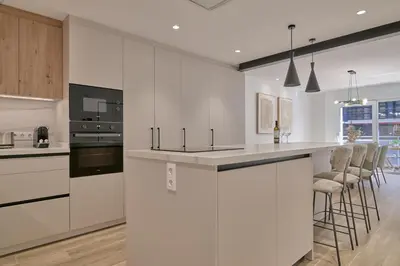 a kitchen with white cabinets and bar stools at Luxury Romantic Apartment Mestalla by Virkin Suites in Valencia