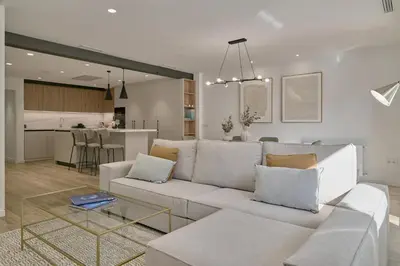 a living room with a white couch and a kitchen at Luxury Romantic Apartment Mestalla by Virkin Suites in Valencia