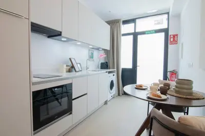 a kitchen with white cabinets and a table with food on it at NOMAD Viveros 02 in Valencia