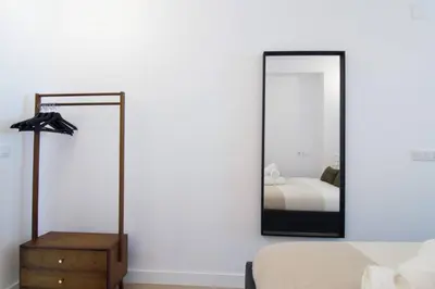 a bedroom with a mirror on the wall and a bed at NOMAD Viveros 02 in Valencia