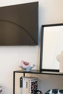 a mirror on a wall next to a table with books at Studio 02 - Les Artes in Valencia