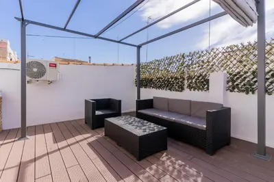 a patio with a couch and a chair and a fan at Modern 2BR Apartment with Terrace in Valencia in Valencia