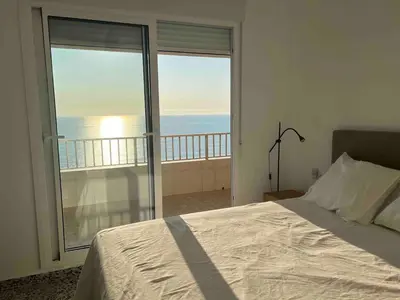 a bedroom with a bed and a view of the ocean at Triton in Mareny Blau