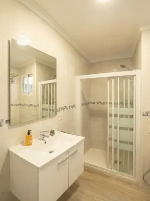 a white bathroom with a sink and a shower at Apartamento moderno en el centro de Tavernes in Tavernes de Valldigna