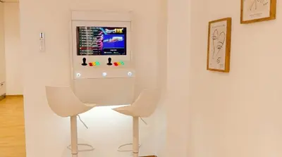 two white chairs in a room with a tv on a wall at Apartamento moderno en el centro de Tavernes in Tavernes de Valldigna