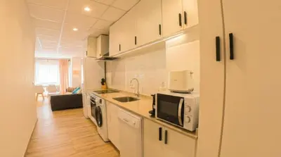 a kitchen with white cabinets and a microwave at Apartamento moderno en el centro de Tavernes in Tavernes de Valldigna