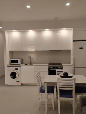 a kitchen with white cabinets and a table and chairs at Iberflat Apartamentos Alfabega in Paterna