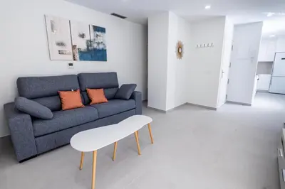 a living room with a blue couch and orange pillows at Iberflat Apartamentos Alfabega in Paterna