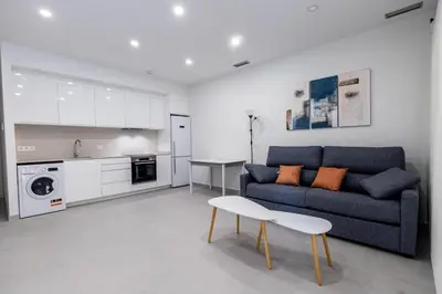 a living room with a couch and a table and a kitchen at Iberflat Apartamentos Alfabega in Paterna