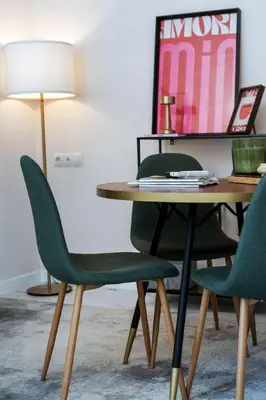 a table with two green chairs and a lamp at Republica Argentina 1 in Valencia
