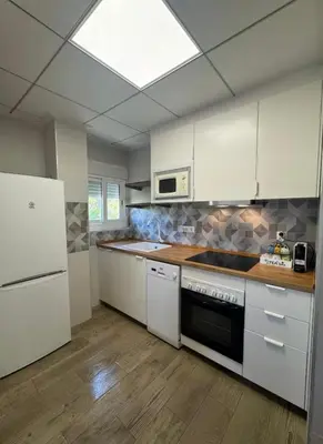 a kitchen with white cabinets and a stove top oven at Chalet Piscina Privada in Barraca de Aguas Vivas