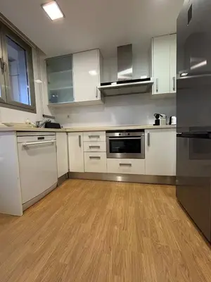 a kitchen with white cabinets and a wooden floor at Relaxing Sea View Apartment - Patacona Beach in Valencia
