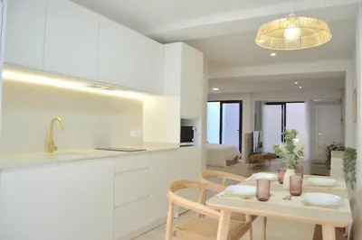a kitchen with white cabinets and a table and chairs at Excepcional moderno y luminoso Terraza privada in Valencia