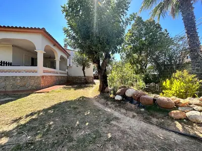 a house with a tree and a stone wall at Casa Mar in Valencia