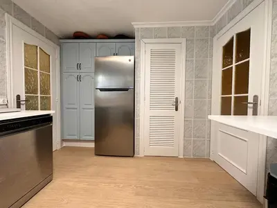 a stainless steel refrigerator in a kitchen with white cabinets at Casa Mar in Valencia