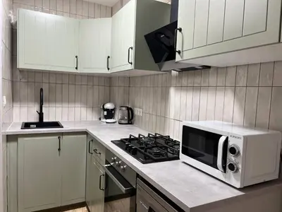 a white kitchen with a microwave and a stove at Pearl by the sea in Valencia