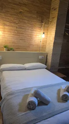 a bedroom with a bed with towels on it at Casita Buenos Aires in Valencia