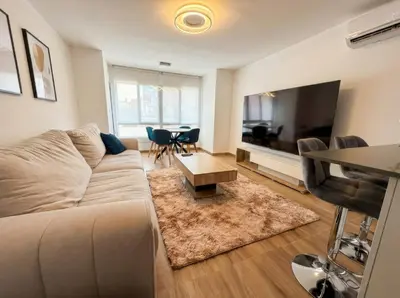 a living room with a couch and a flat screen tv at Ático Premium Centro de Tavernes, Terraza & BBQ in Tavernes de Valldigna