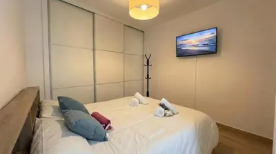 a bedroom with a large white bed with pillows at Ático Premium Centro de Tavernes, Terraza & BBQ in Tavernes de Valldigna