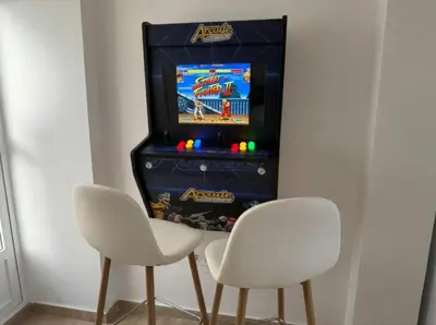 two white chairs next to a video game system at Ático Premium Centro de Tavernes, Terraza & BBQ in Tavernes de Valldigna