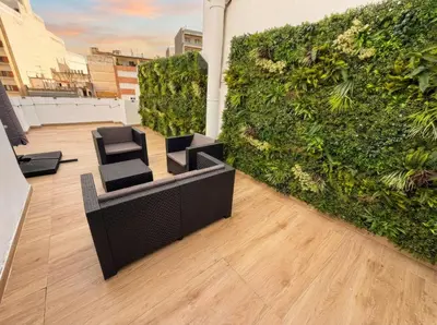 a living wall with two chairs and a couch on a building at Ático Premium Centro de Tavernes, Terraza & BBQ in Tavernes de Valldigna