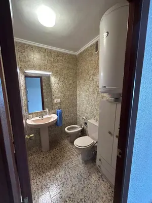 a bathroom with a sink and a toilet and a mirror at Apartamento Perellonet Mascaró in El Perellonet