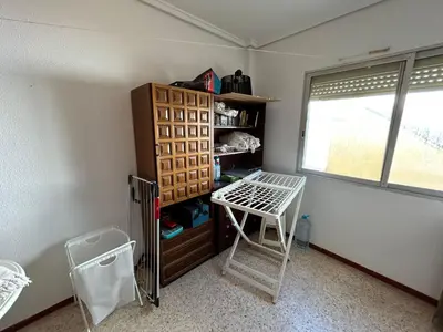 a room with a shelf and a table and a window at Apartamento Perellonet Mascaró in El Perellonet