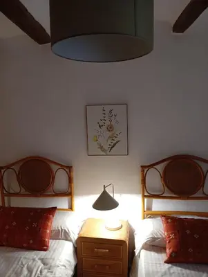 a bedroom with two beds and a lamp and a table at Casa La Villa in Requena