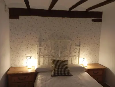 a bedroom with a bed with two nightstands and two lamps at Casa La Villa in Requena