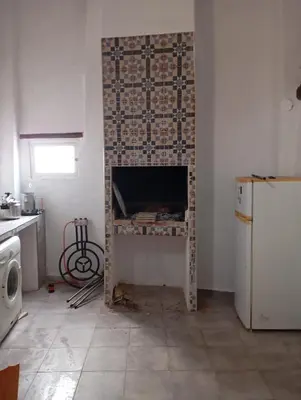 a kitchen with a fireplace with a brick wall at Casa La Villa in Requena