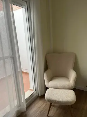 a living room with a chair and a book shelf at Puzol Playa in Puzol