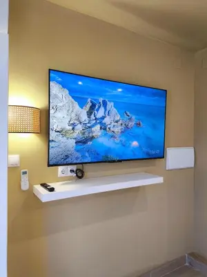 a flat screen tv hanging on a wall at Calma Verde Your getaway in Playa de Valencia in Valencia