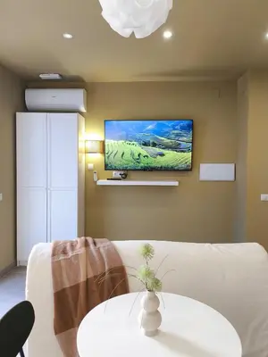 a living room with a white couch and a flat screen tv at Calma Verde Your getaway in Playa de Valencia in Valencia