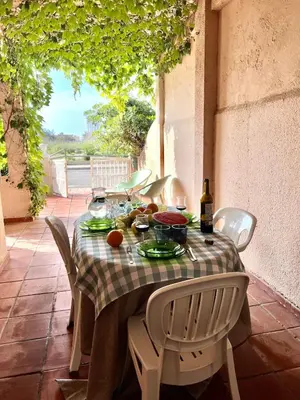 a table with food and wine on a patio at Casa Enredadera in Mareny Blau