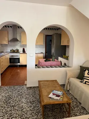 a kitchen and a living room with a couch at Casa Enredadera in Mareny Blau
