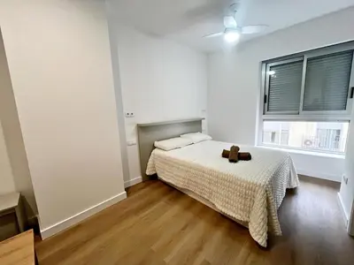 a white bedroom with a bed and a window at Loft en el Centro De Valencia Botánico 1 in Valencia