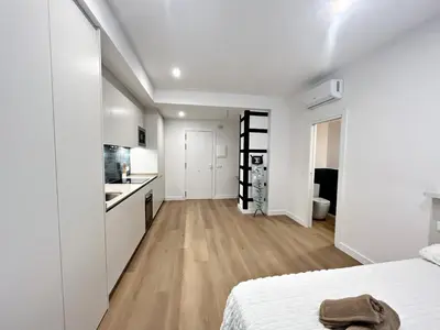 a white bedroom with a bed and a kitchen at Loft en el Centro De Valencia Botánico 2 in Valencia