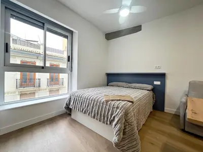 a bedroom with a bed and a large window at Loft en el Centro De Valencia Botánico 4 in Valencia